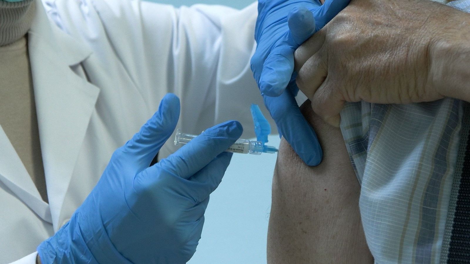 Una enfermera vacuna a un usuario en un centro de salud.