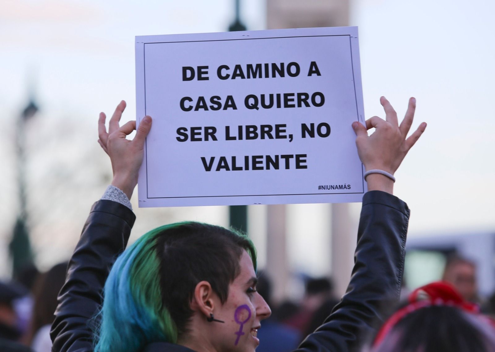 Una mujer alza una pancarta en una manifestación por el 8M.
