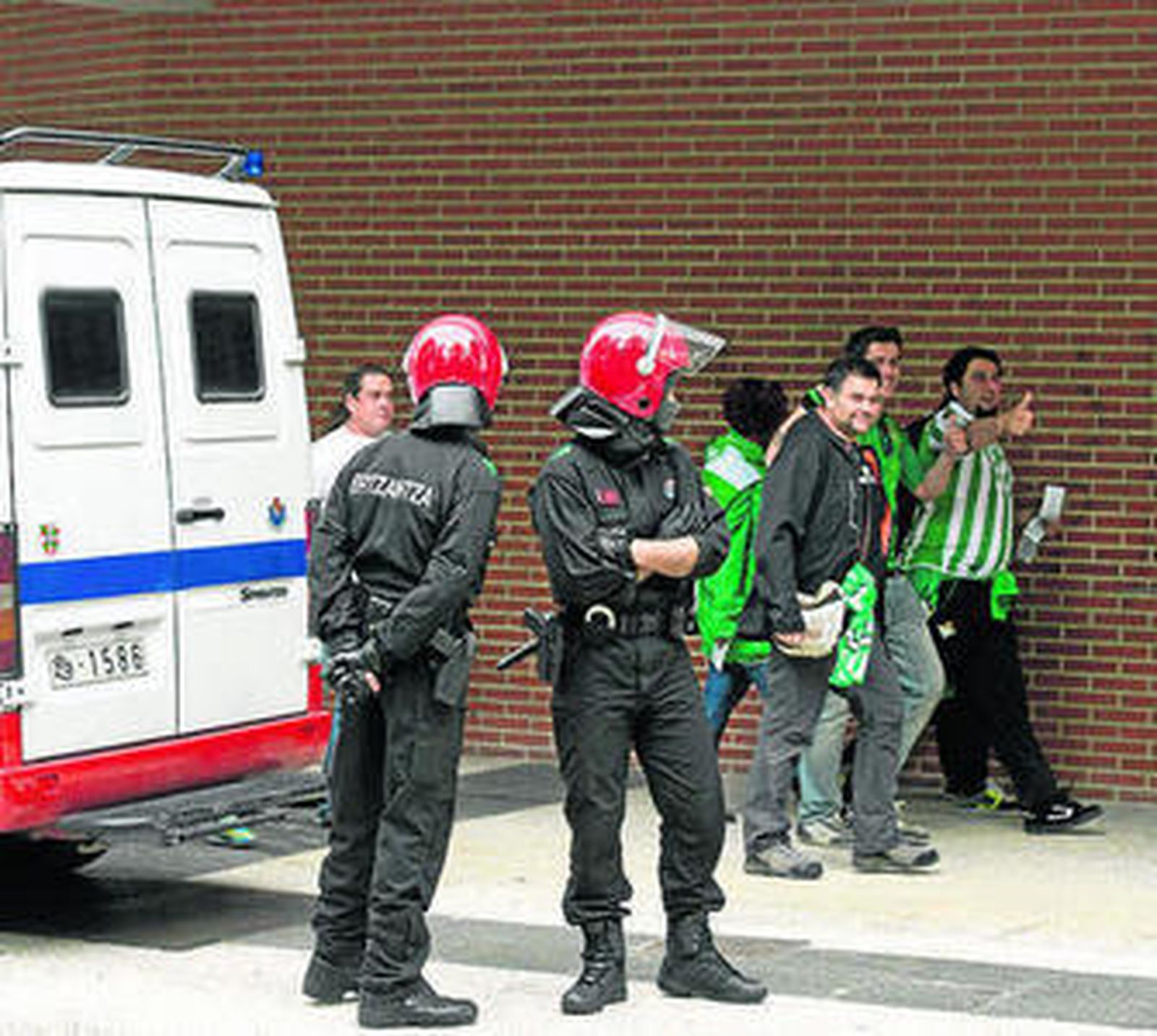 Aficionados béticos escoltados por la Erzaintza.