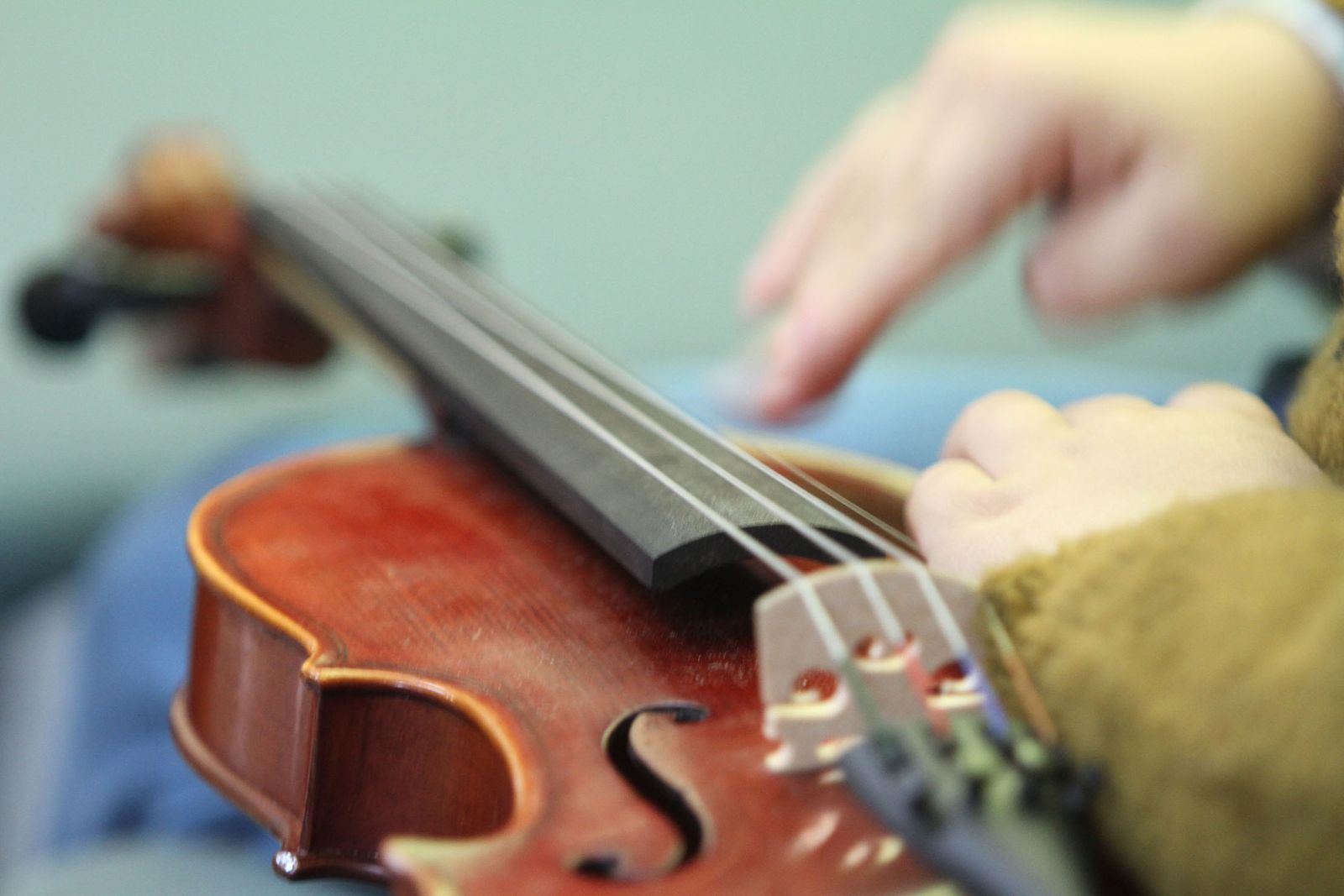 Un niño toca las cuerdas de un violín.