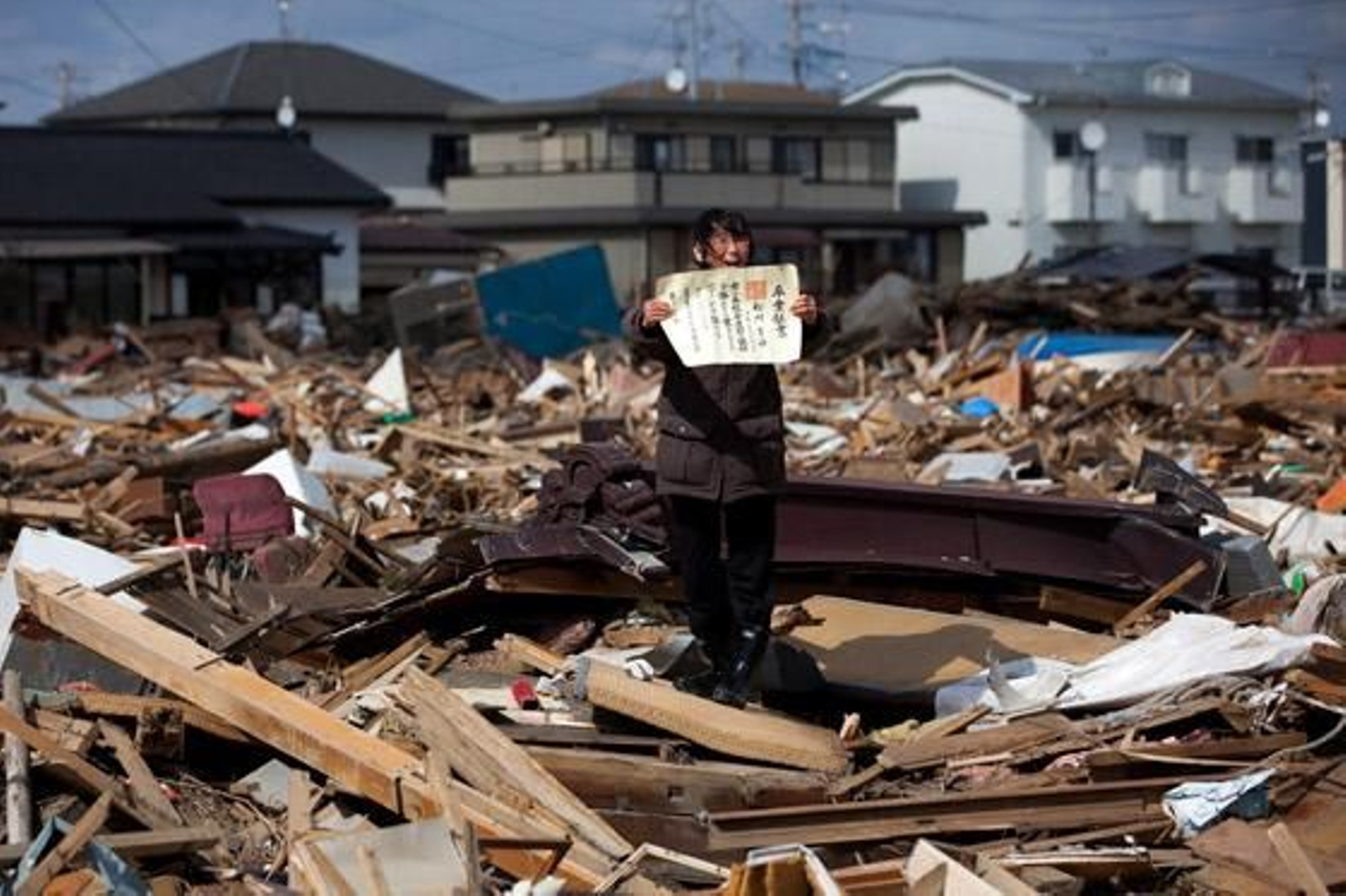 Chieko Masukawa muestra el certificado de graduación de su hija, que ha encontrado entre los escombros tras el tsunami que arrasó la ciudad de Higashimatsushima, en la prefectura de Miyagi. Es una imagen tomada de Yasuyoshi Chiba, de la agencia AFP. / Chieko Masukawa