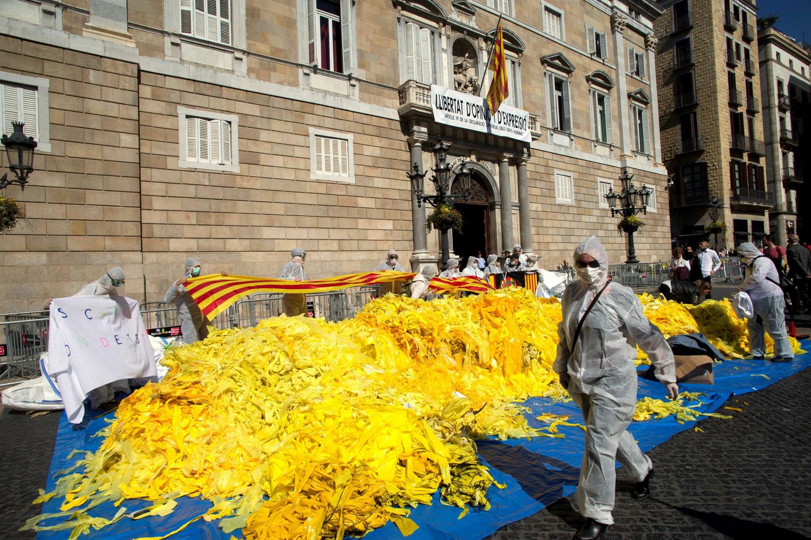 Antiindependentistas vuelcan sacos de lazos amarillos frente a la Generalitat