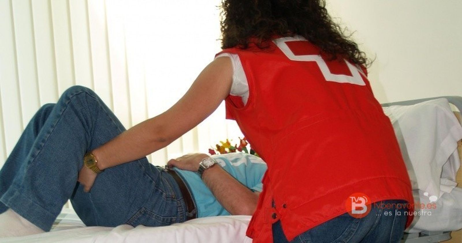 Una asistente de Cruz Roja realiza cuidados a un dependiente.