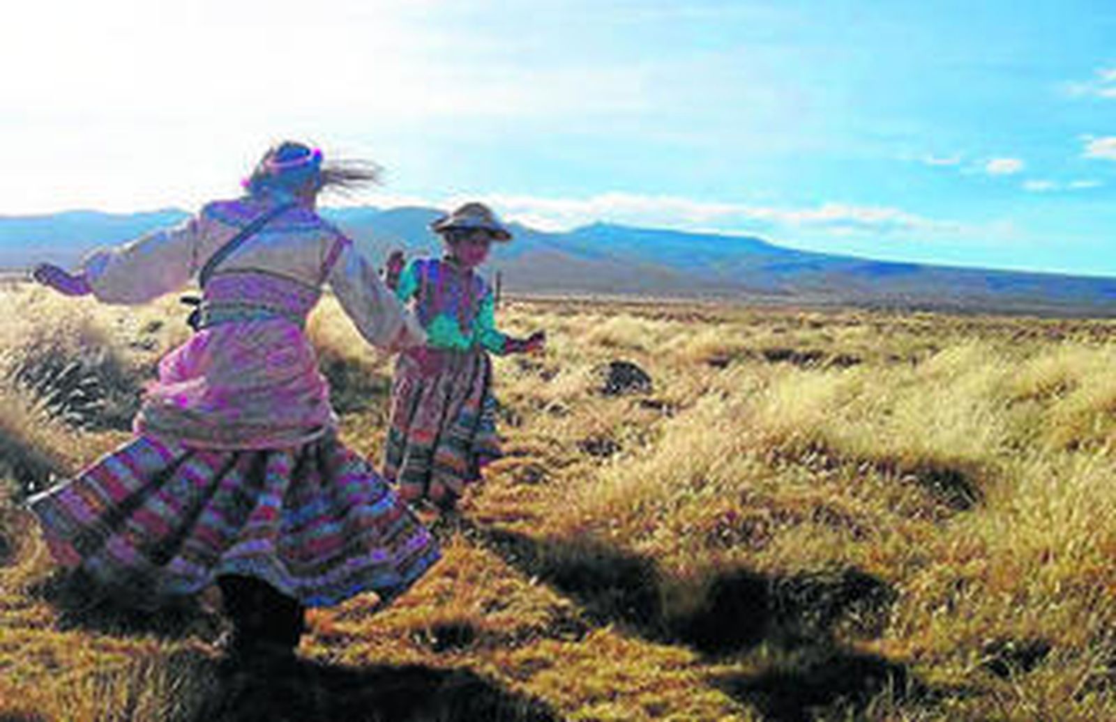 Dós jóvenes en la planicie de Arequipa. Debajo, un rebaño de alpacas.
