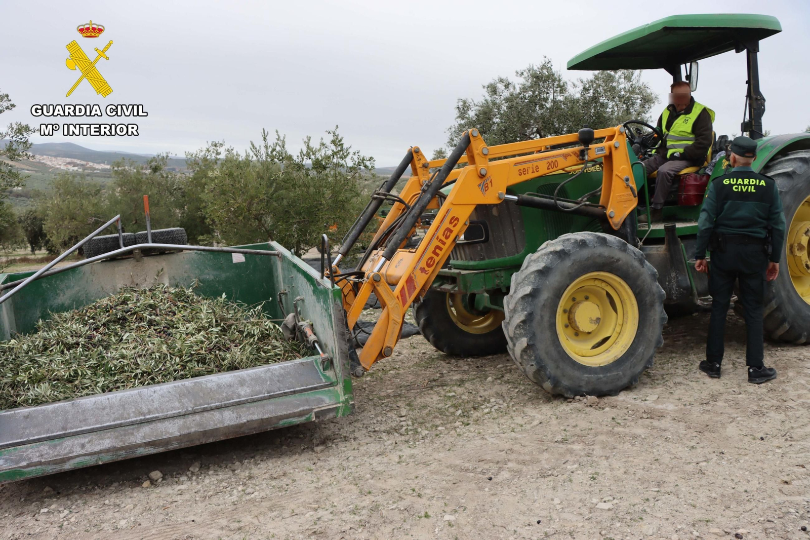 Un agente de la Guardia Civil conversa con un tractorista.