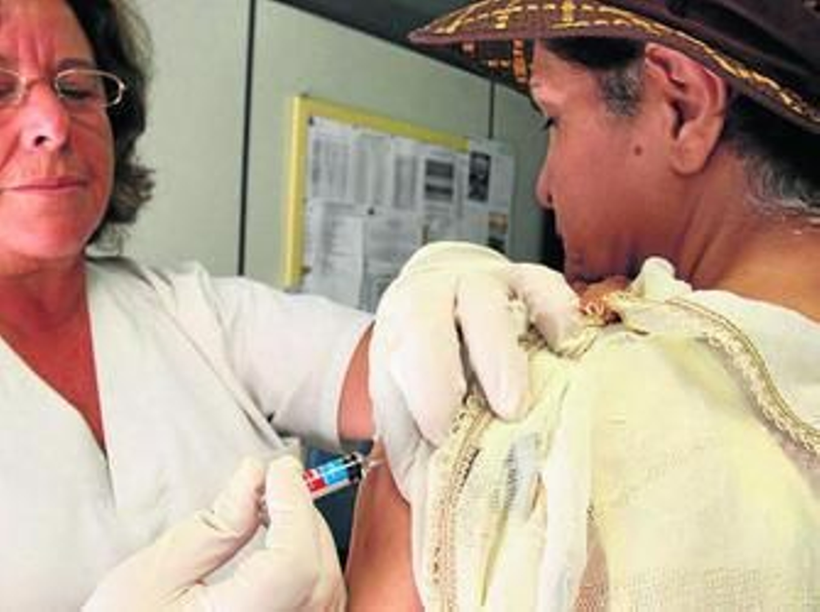 Una enfermera inyecta una vacuna contra la gripe.