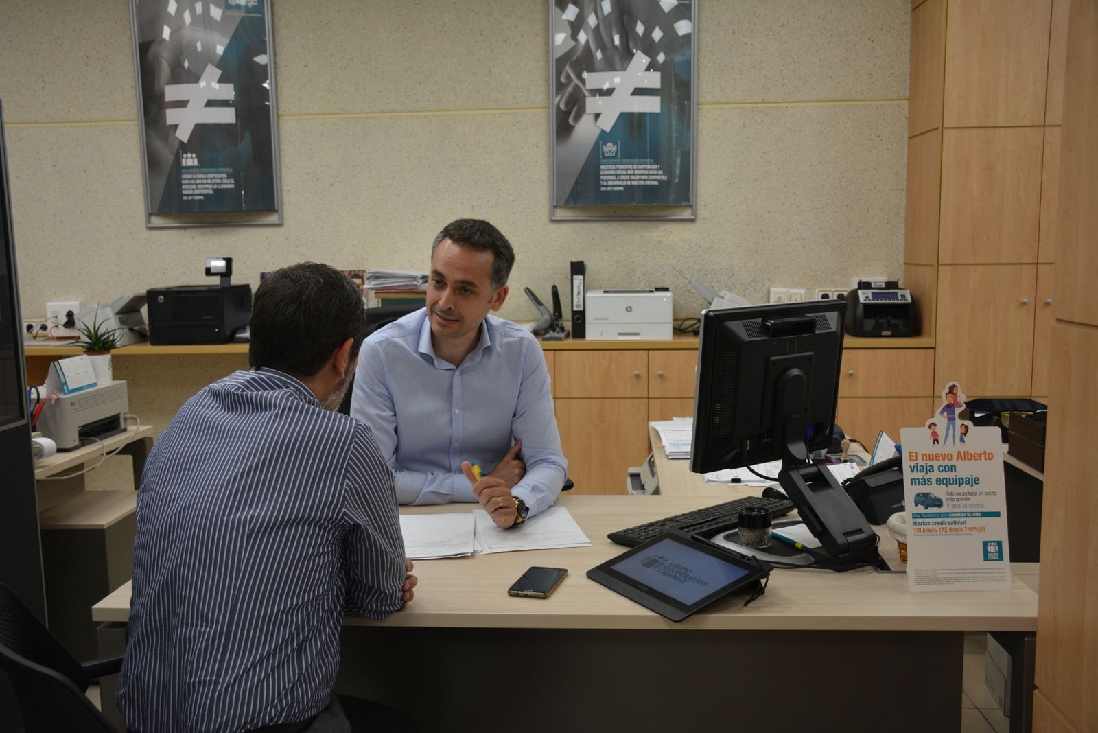 Un trabajador de Cajamar atiende a un cliente