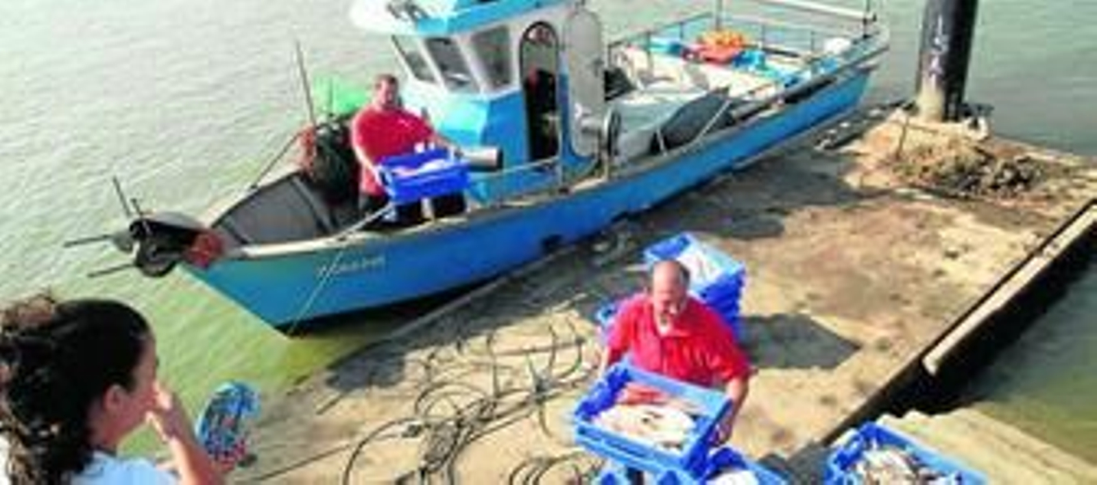 Una embarcación tradicional llega a descargar al puerto de El Rompido.