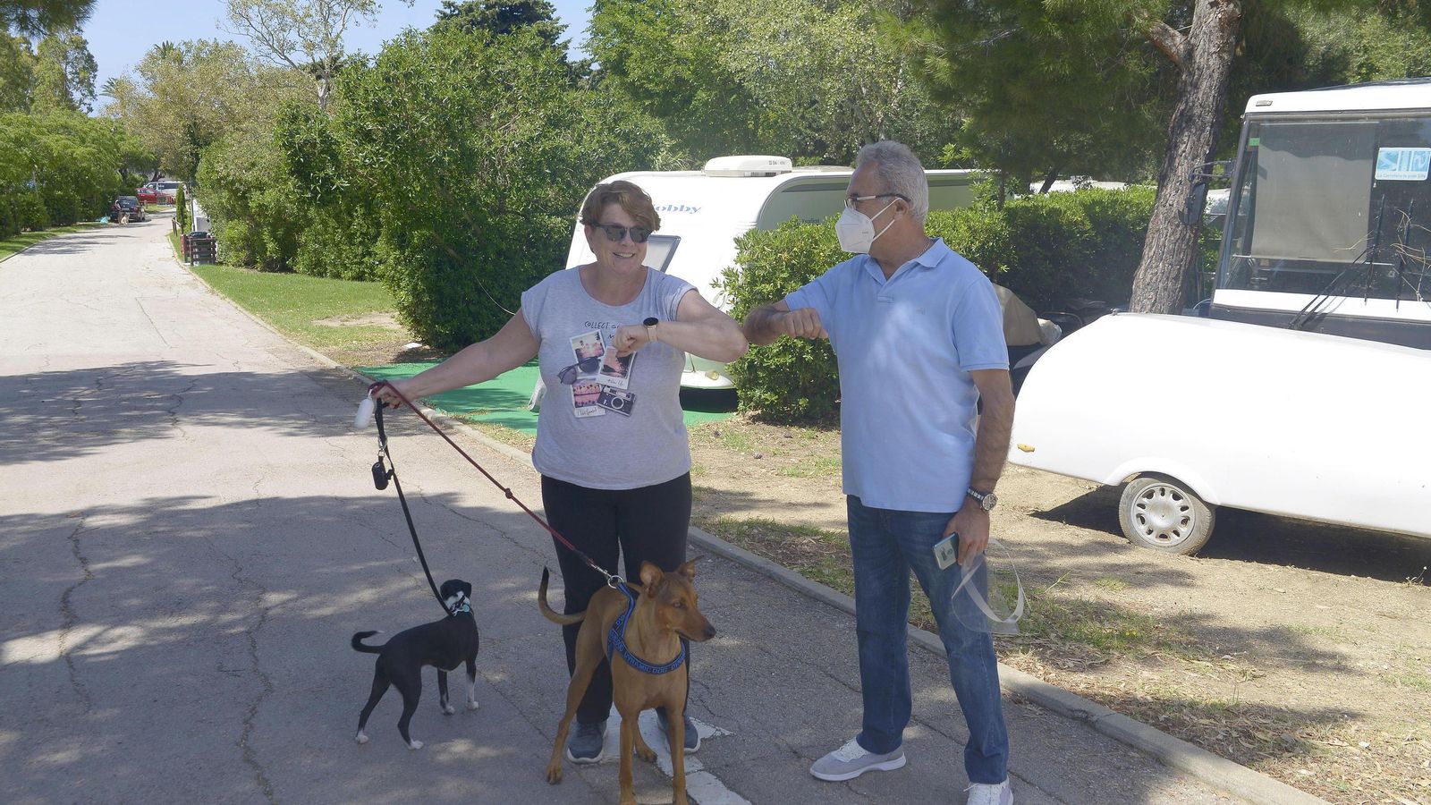 José Antonio Santos, propietario del Camping Valdevaqueros, choca los codos con una cliente alojada en el recinto.