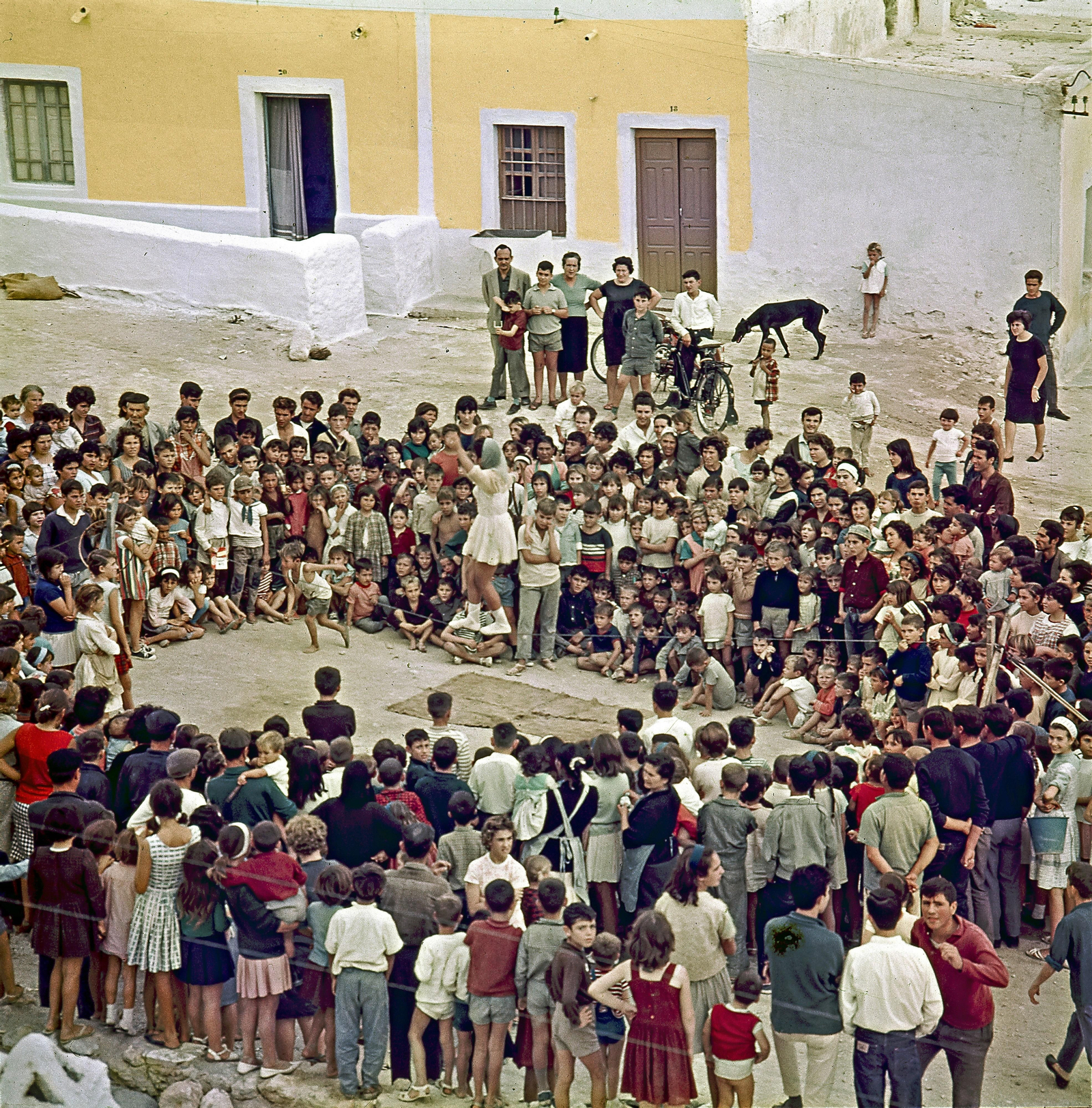 Todos los chavales y chavalas del barrio asisten a un espectáculo de equilibrismo en el barrio.