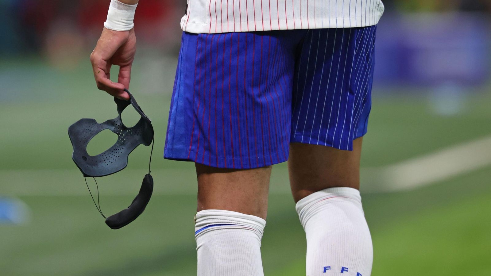 Kylian Mbappé sostiene su máscara protectora tras el final de la primera mitad.