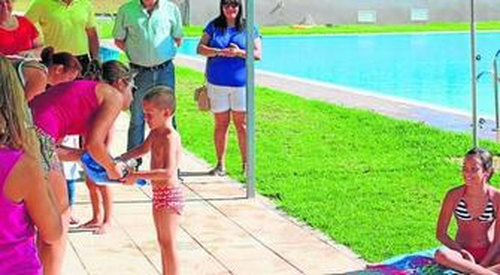 Uno de los pequeños recoge el diploma de natación.