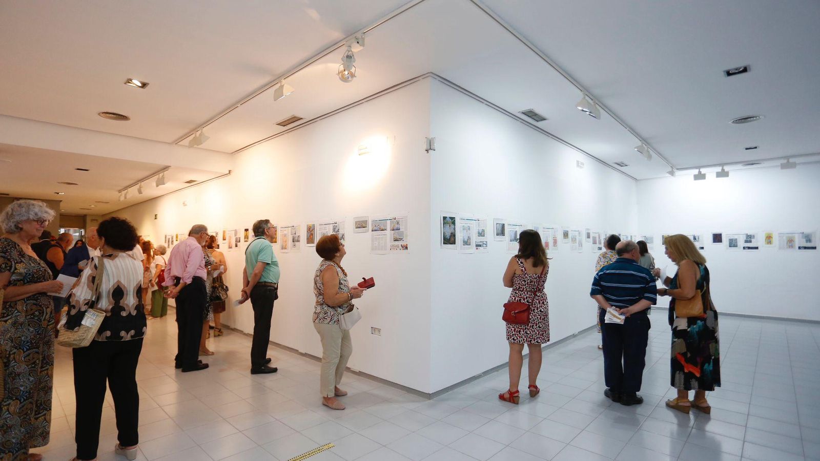 Un grupo de personas observando el trabajo en la sala Cajasur.