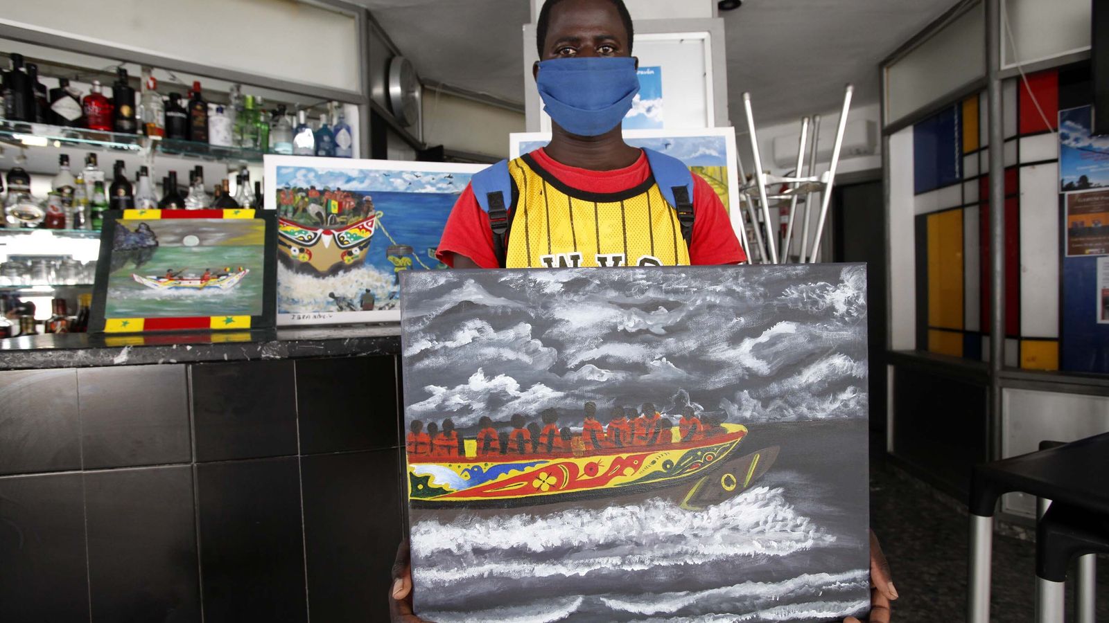 Niang con una de sus obras en las que muestra la travesía en cayuco en busca de una vida mejor