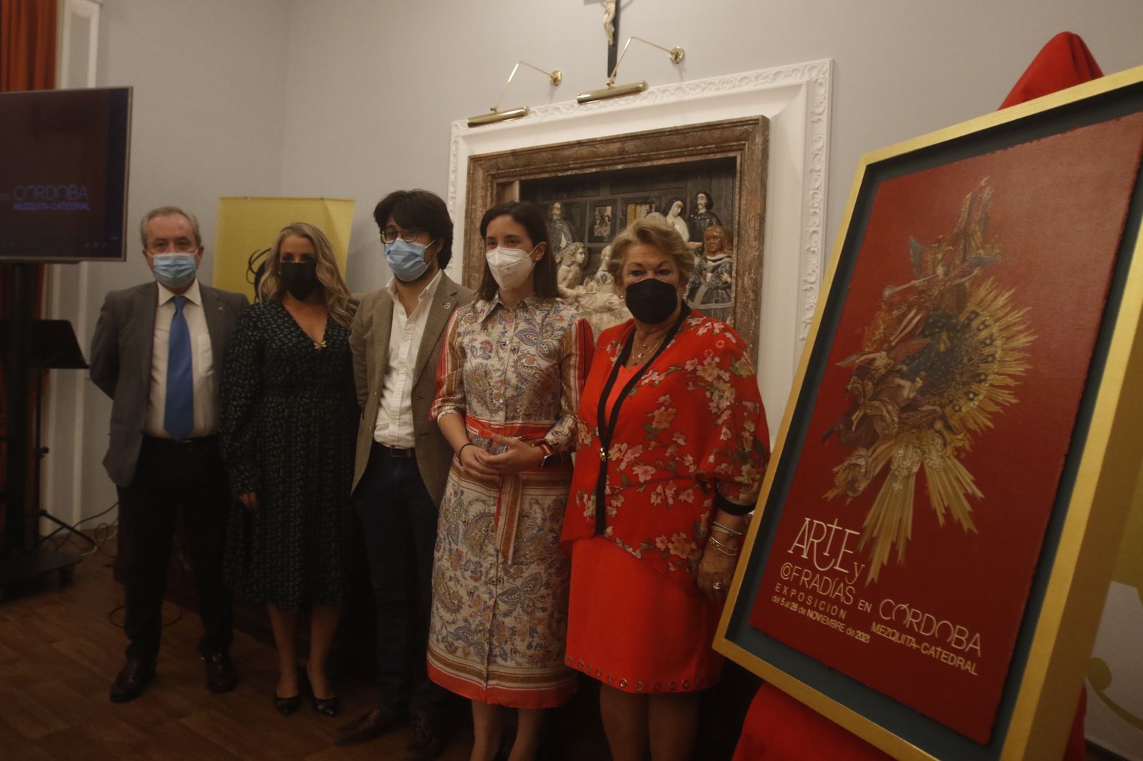 Las autoridades presentes, junto al cartel anunciador de la exposición.