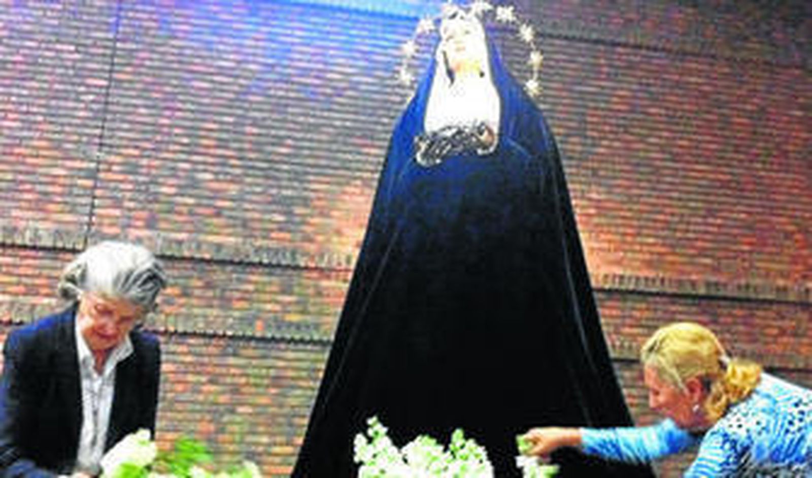 Hermanas de Amor y Sacrificio poniendo las flores en el paso, ayer por la mañana.