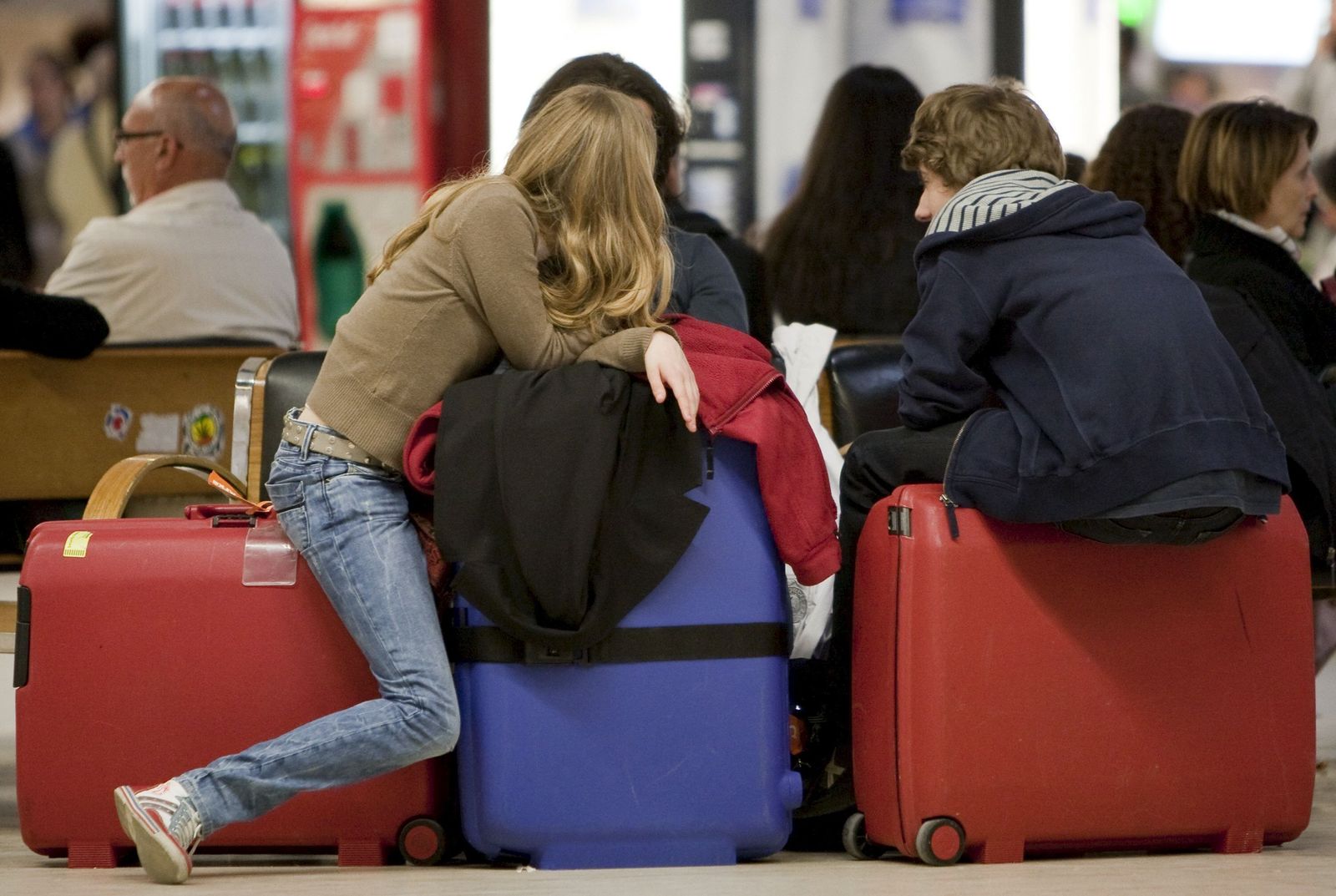 Jóvenes esperando con sus maletas para partir del aeropuerto de Sevilla.