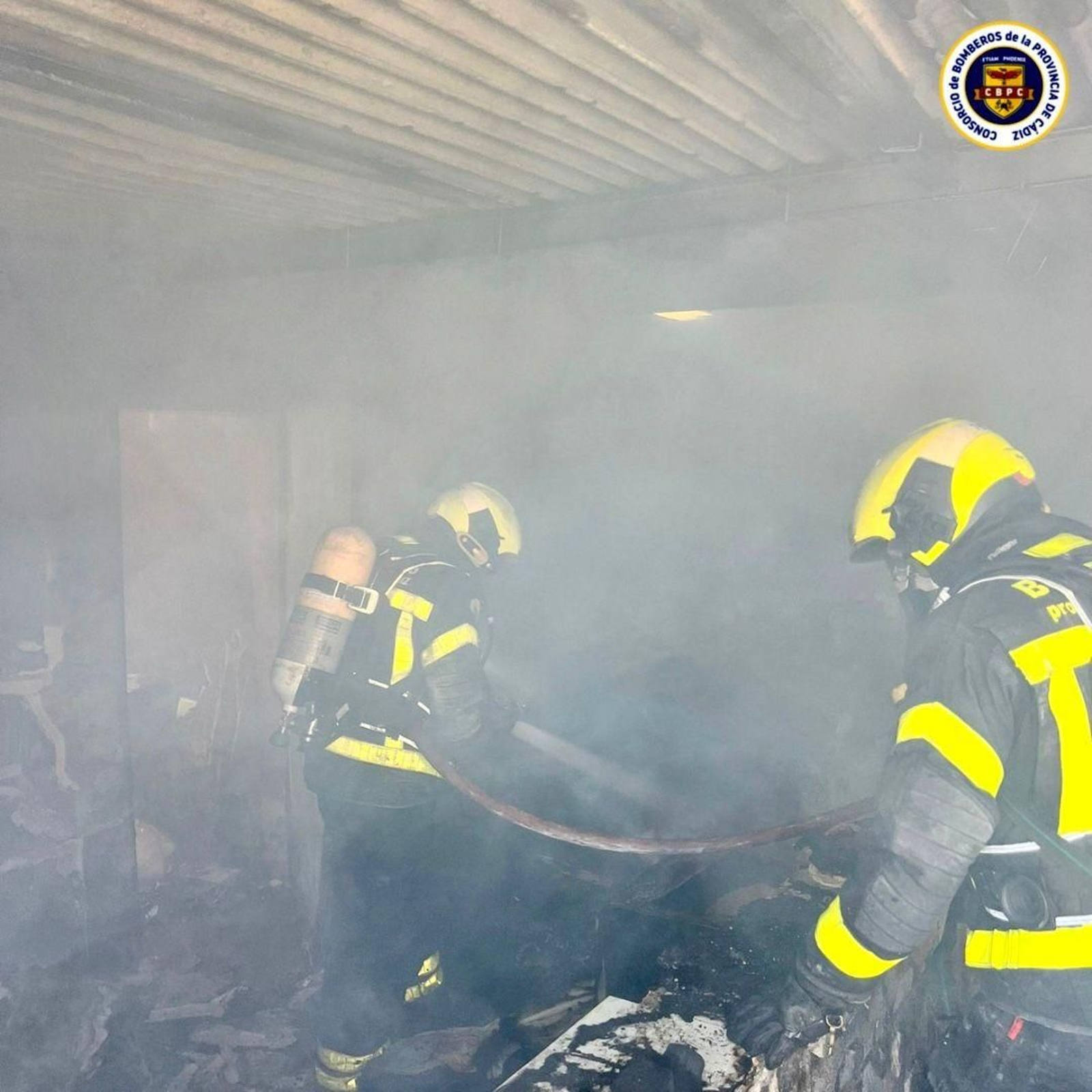 Los bomberos apagan en el incendio en el garaje del Pinar de los Franceses en Chiclana.