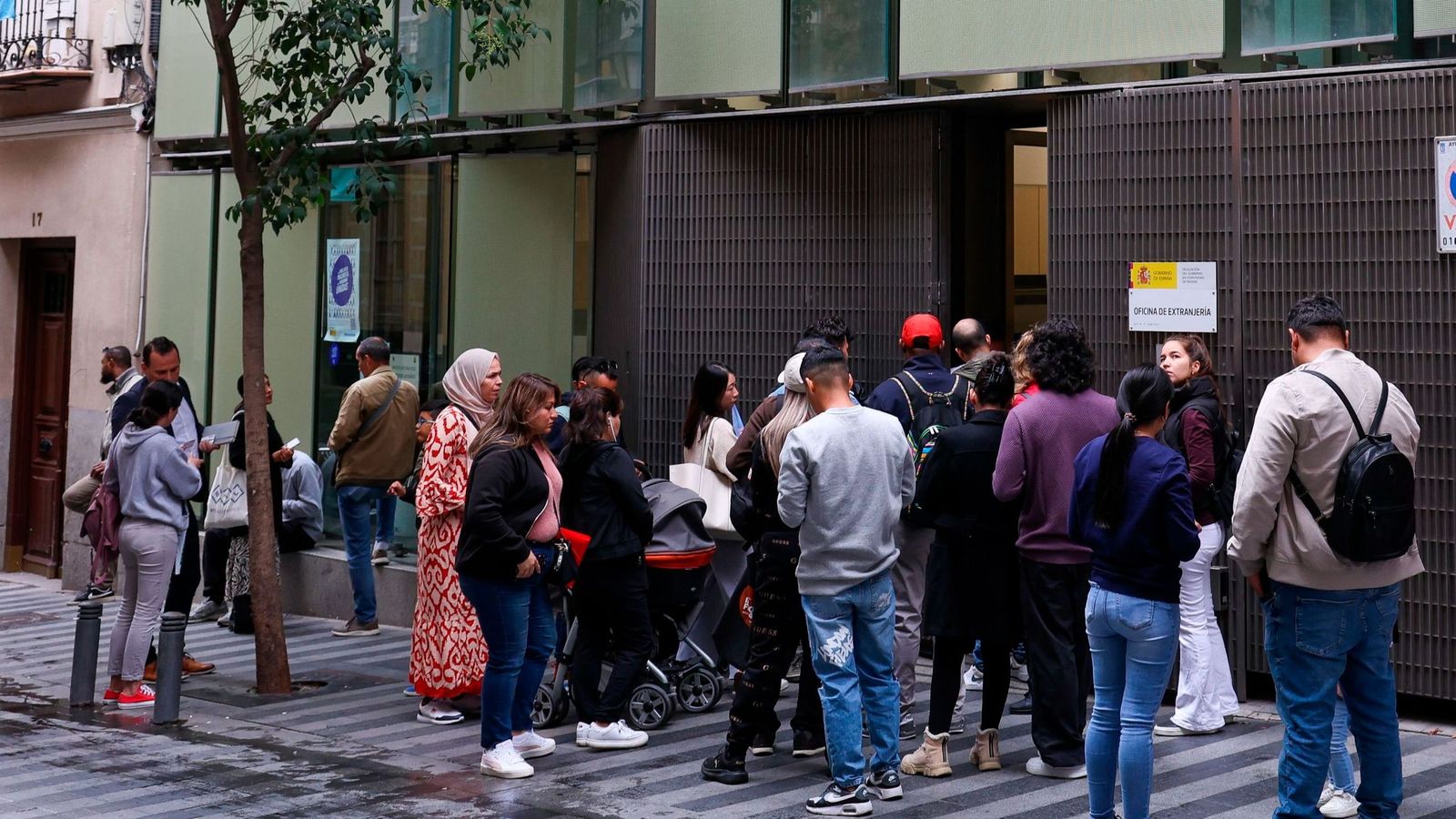 Personas haciendo cola en una Oficina de Extranjería en España.