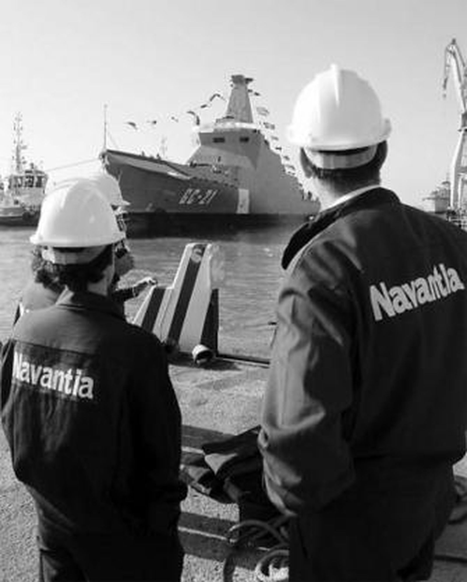Momento en que el Buque de Vigilancia Litoral sale a aguas de la Bahía, mientras un grupo de la plantilla del centro de San Fernando se manifiesta con pancartas.