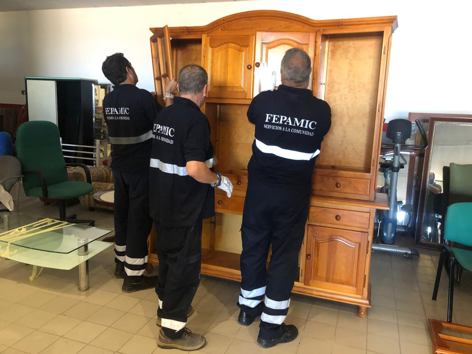 Personal de Fepamic, montando uno de los muebles recogidos.