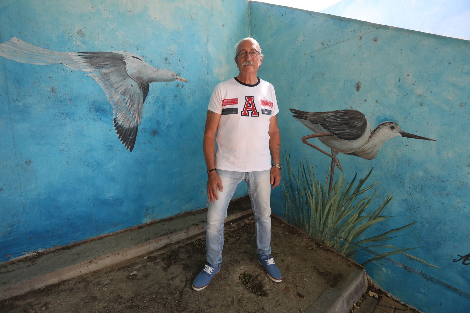Antoni Gabarre, ante uno de sus murales situado junto a la pasarela de madera del Río Iro