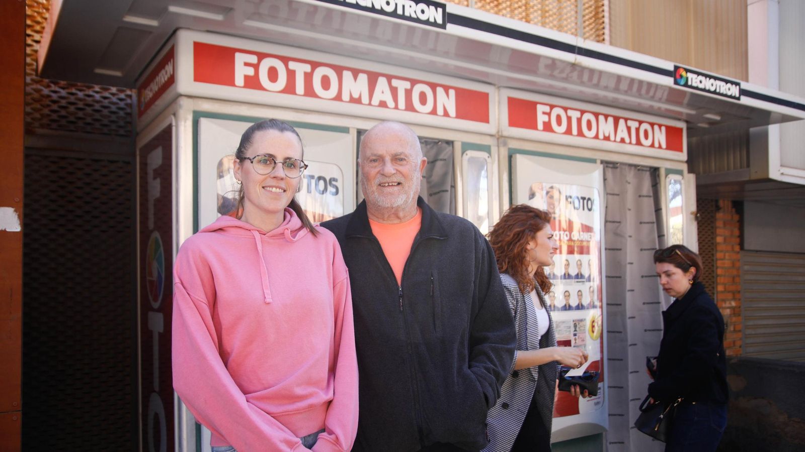 Eli y su padre posan frente al fotomatón.