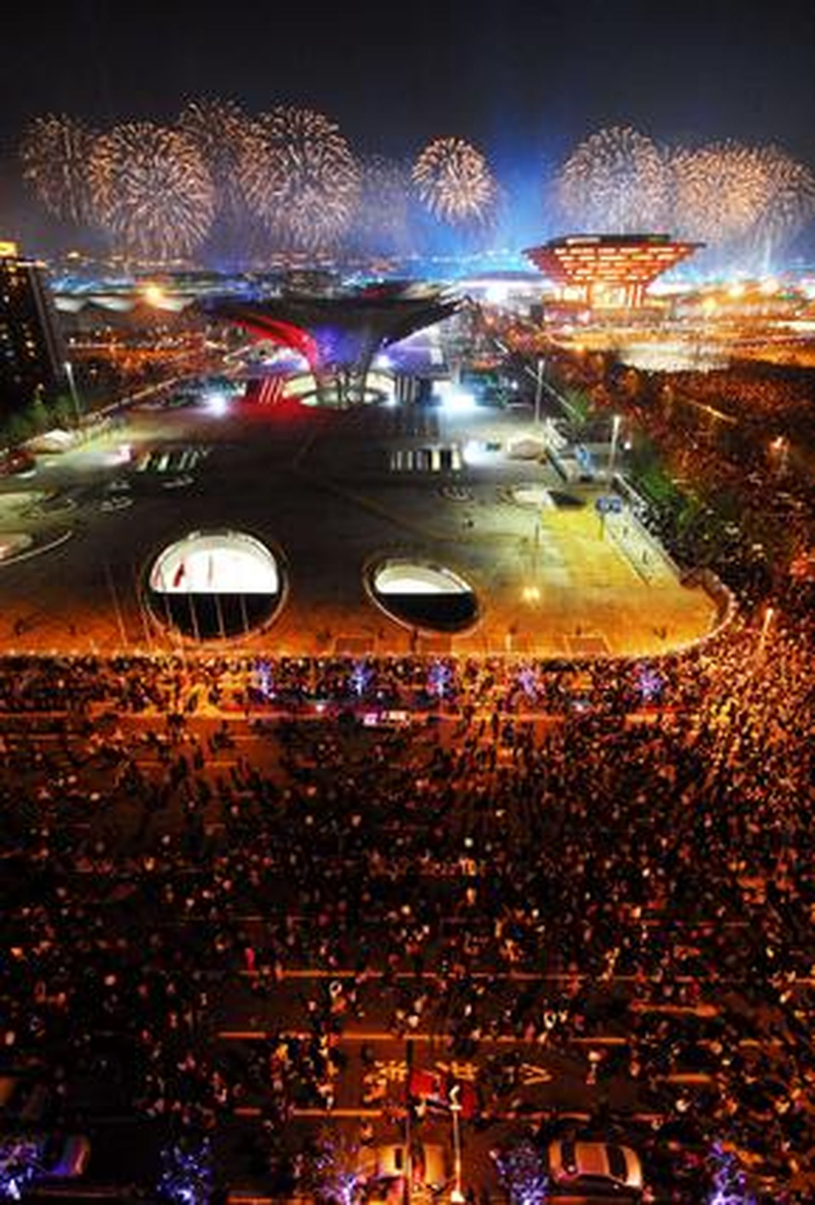 Imagen vertical que permite observar a la gente en la calle y al fondo los fuegos artificiales.

Foto: AFP Photo