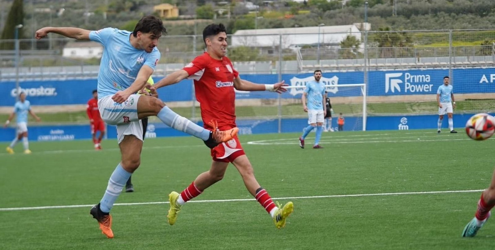 Ricky golpea el balón en presencia de un rival. Ricky golpea el balón en presencia de un rival.