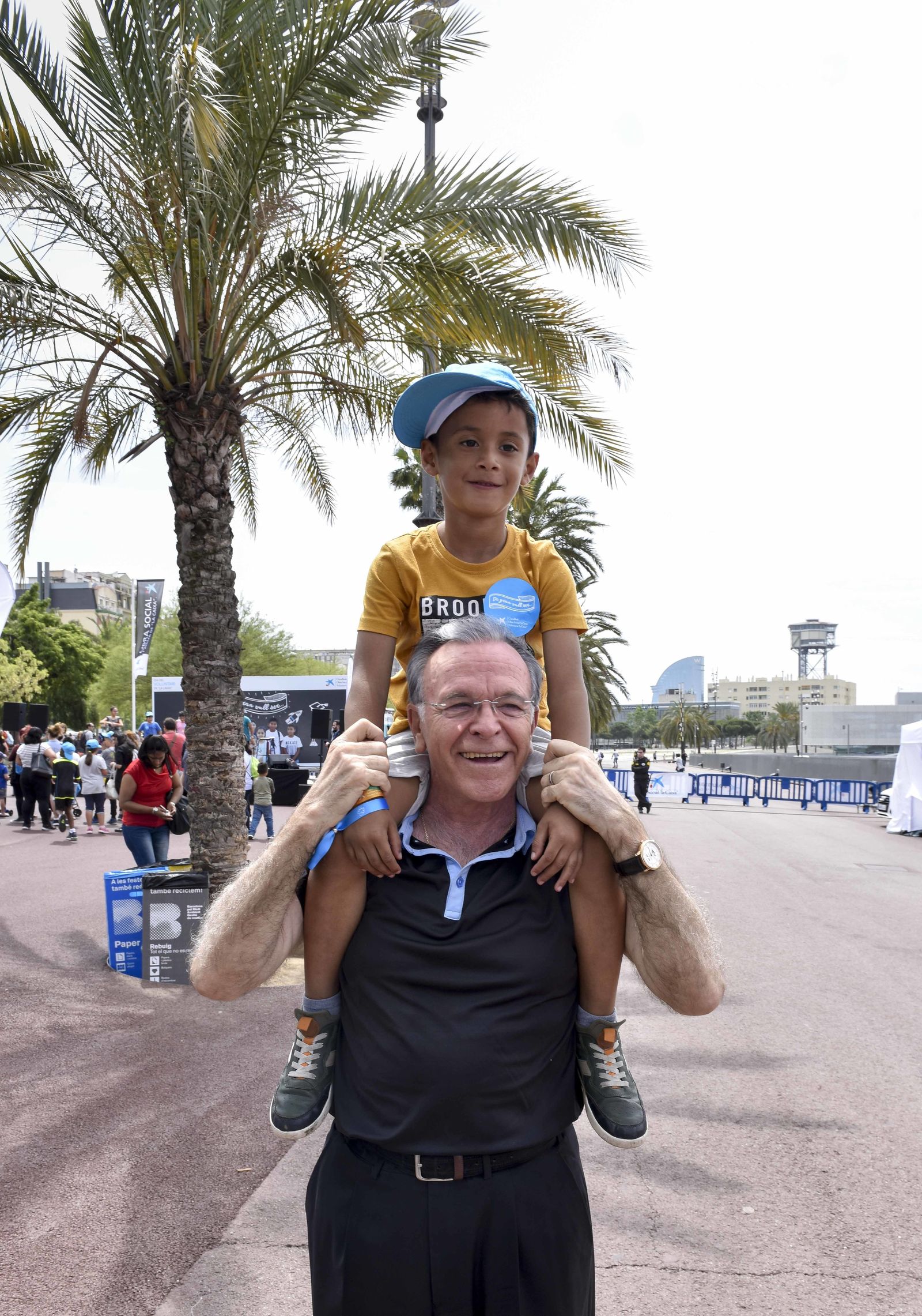 Isidro Fainé lleva a un niño en hombros en el Día de Voluntariado de La Caixa.