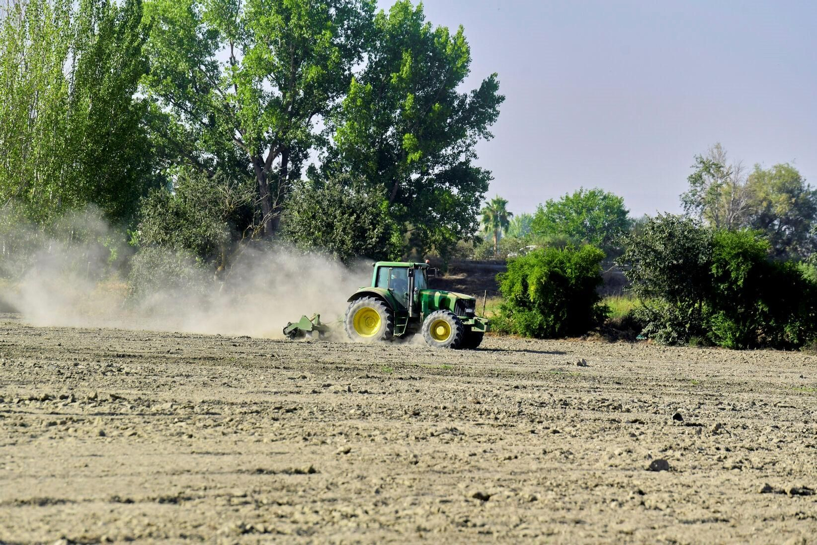 Agricultor trabajando en un campo con su tractor .