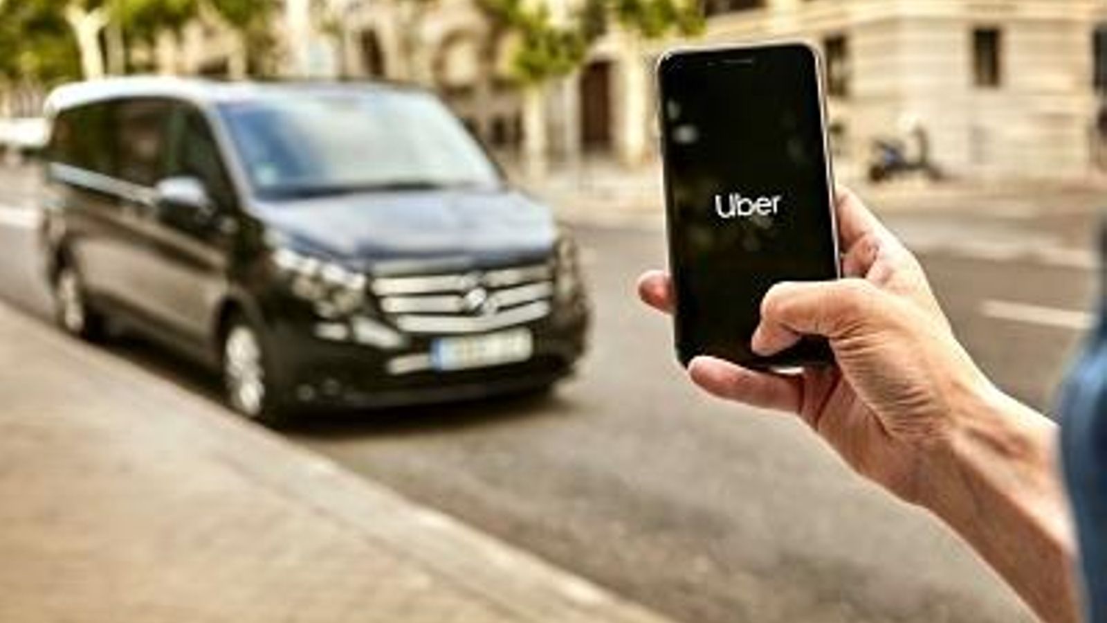 Un usuario de Uber Van ante uno de sus coches para grupos.