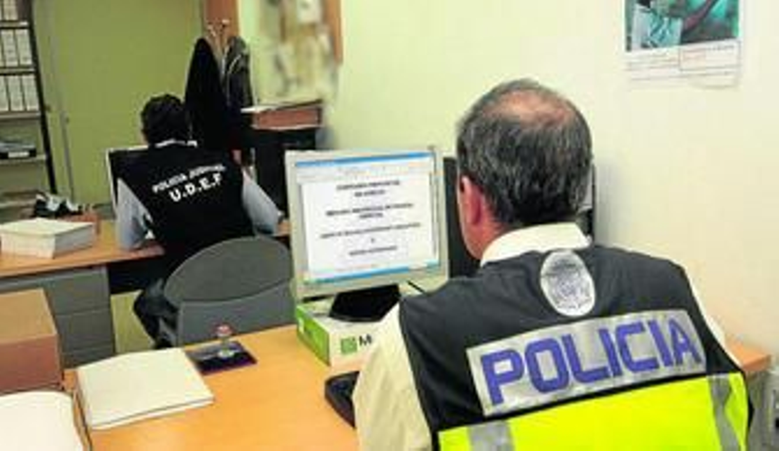 Dos agentes de la Policía Judicial trabajando con ordenadores en la comisaría de Huelva.
