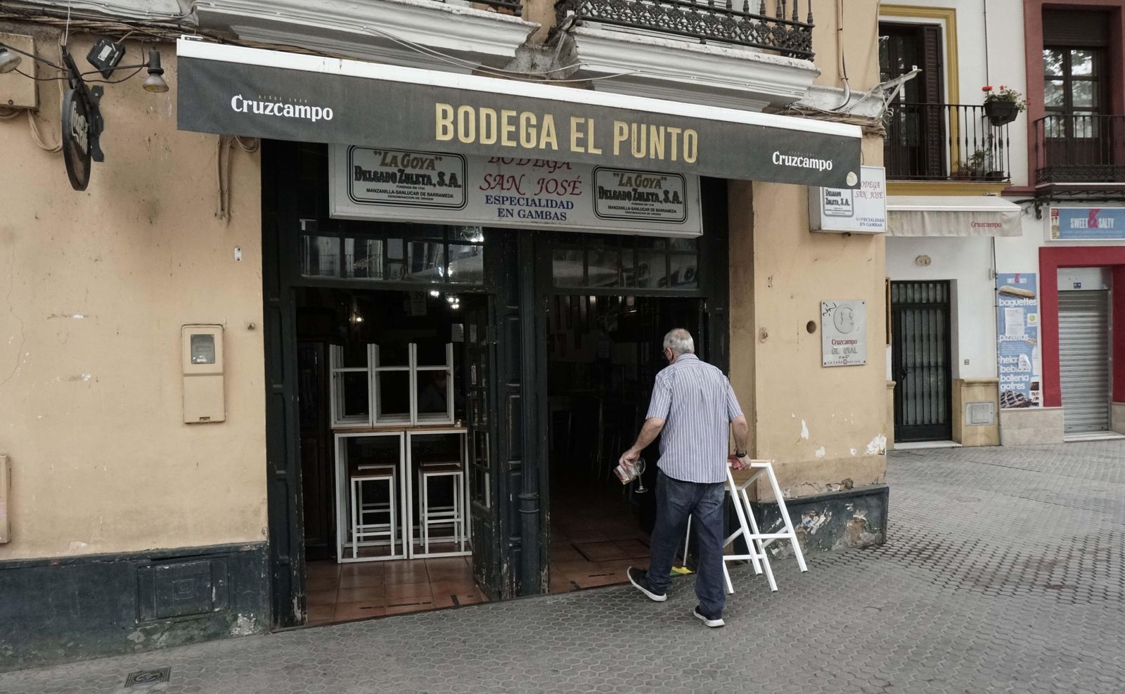 Nicolás Bueno recoge un taburete de la terraza, en el número 10 de la calle Adriano.