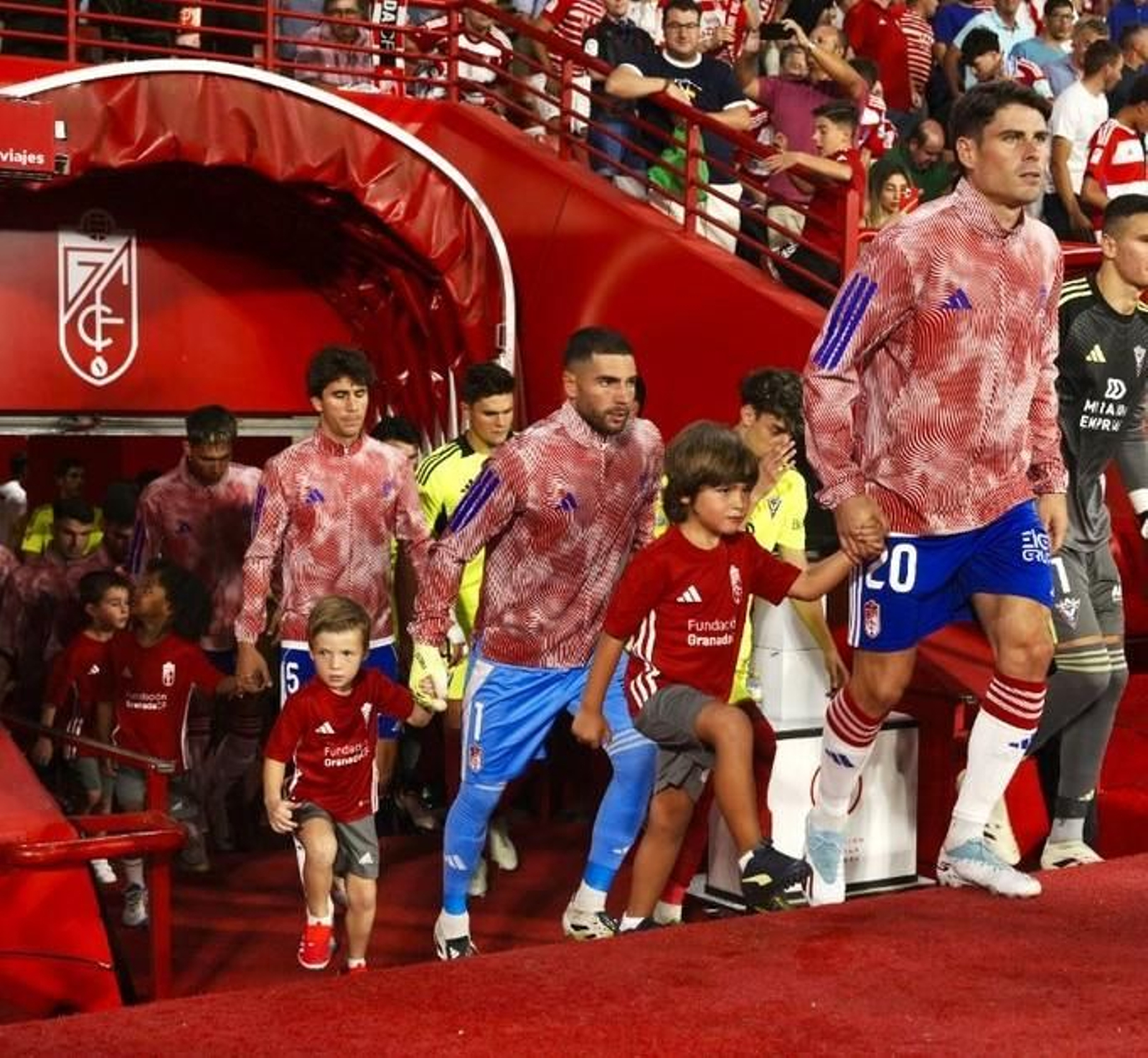 Jugadores y niños de las escuelas rojiblancas antes del Granada-Mirandes del domingo