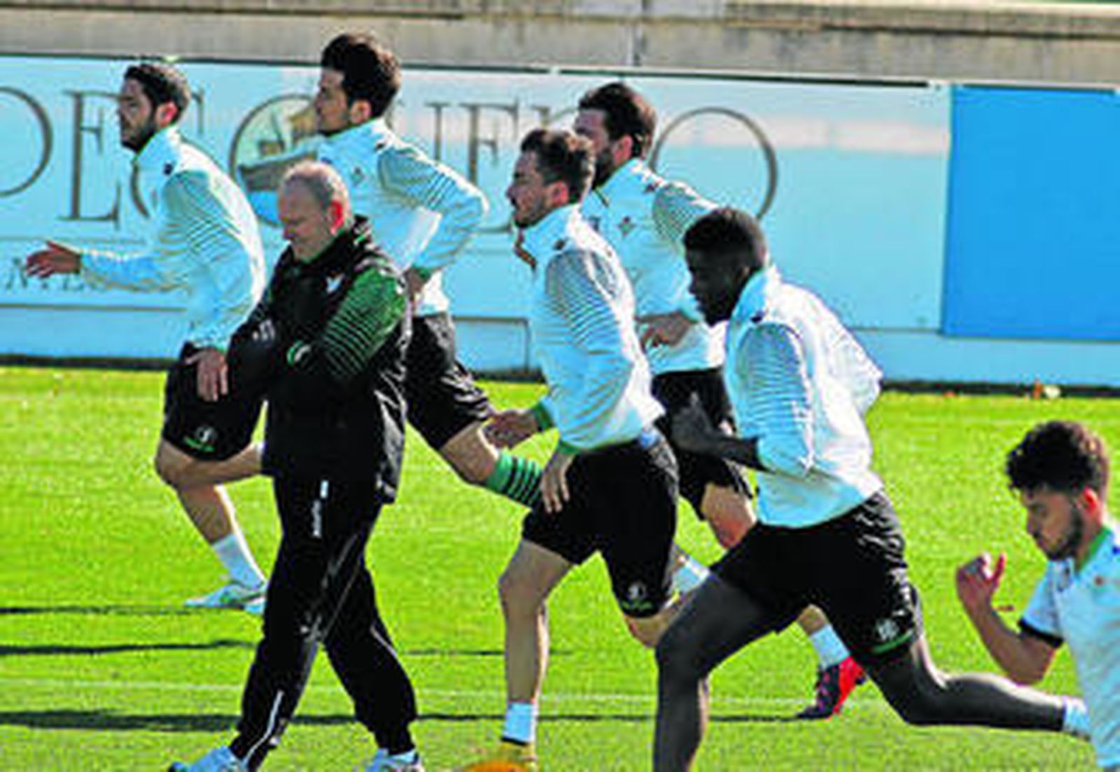 Mel controla el tiempo de la carrera de sus futbolistas en el entrenamiento.