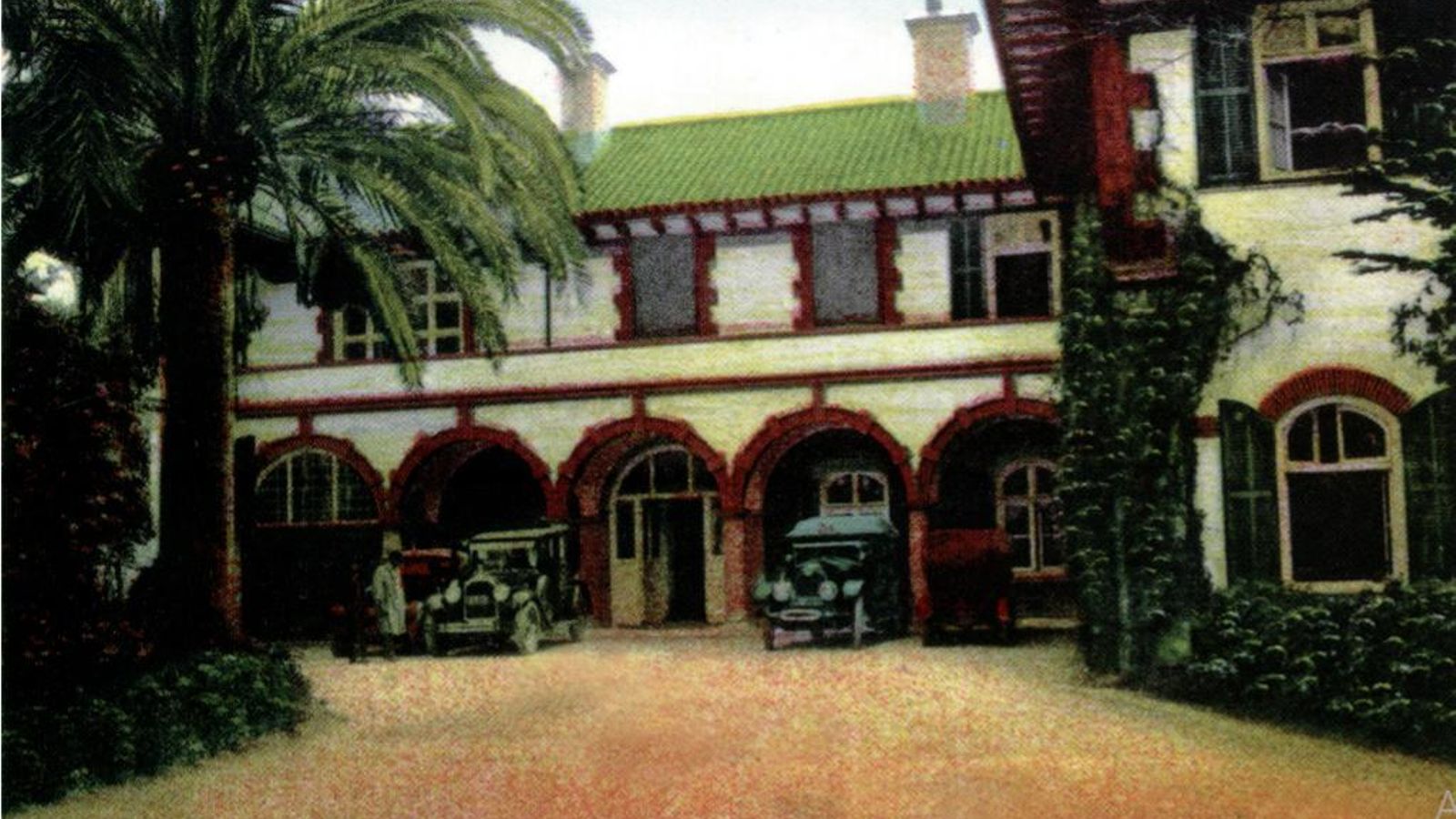 Postal coloreada que muestra la entrada principal del Hotel Reina Cristina hacia el año 1927 con el aspecto que tenía antes de sufrir el incendio en enero de 1930. Obsérvese que entonces sólo tenía dos plantas.