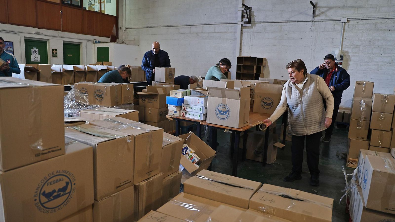 Varios voluntarios ayudan a clasificar los alimentos que han recibido.