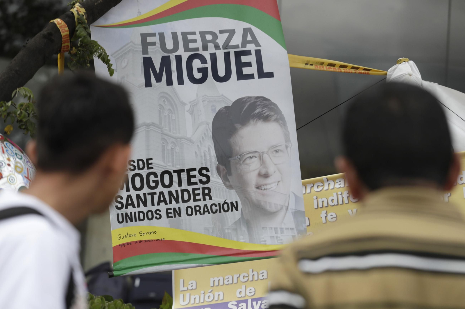 Varias personas rezan en un altar improvisado frente a la Fundación Santa Fe, donde estaba hospitalizado el senador colombiano Miguel Uribe Turbay.