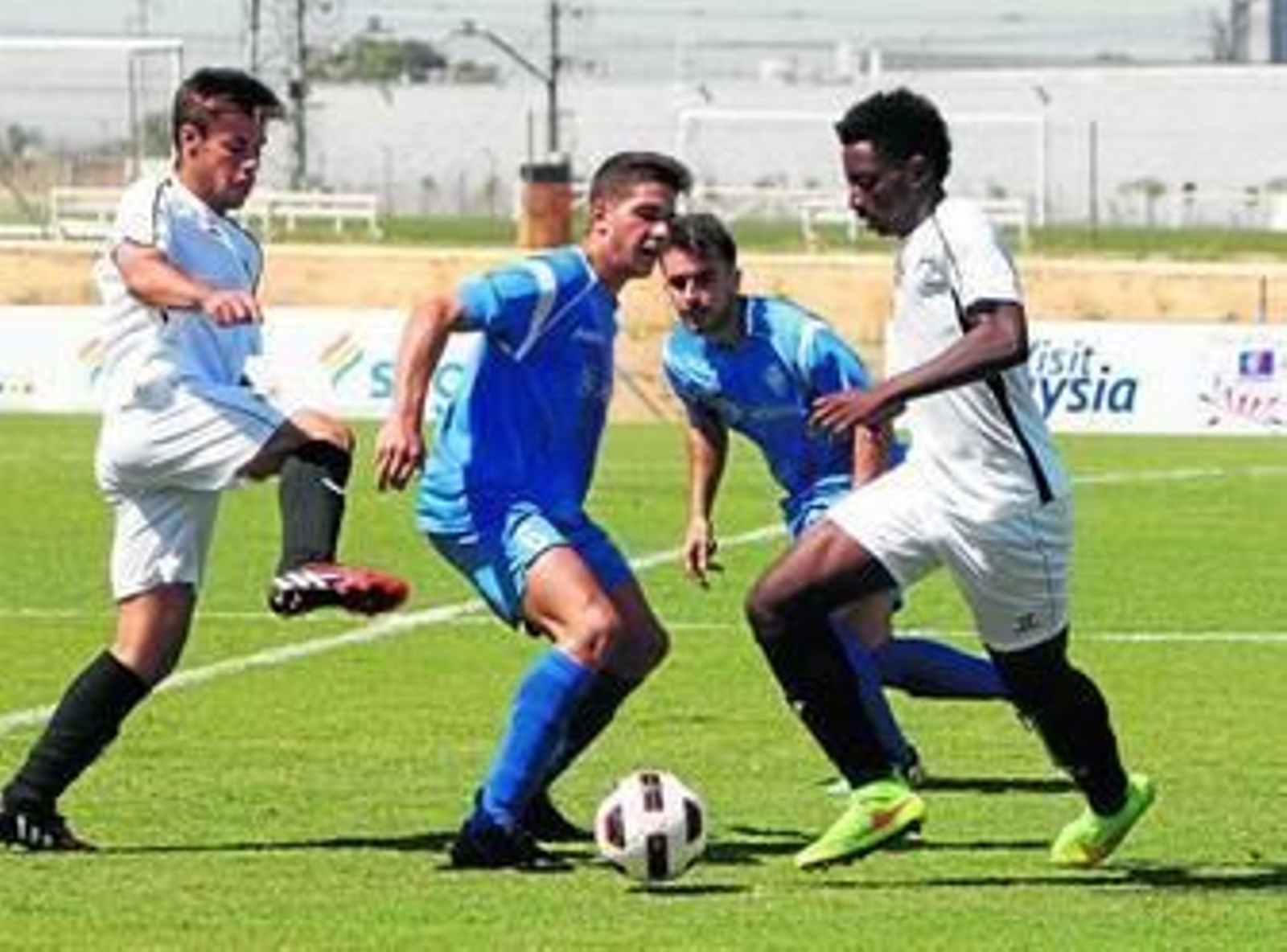 Yan Brice controla un balón ante la oposición de un futbolista del Maracena con la ayuda de Zelu.