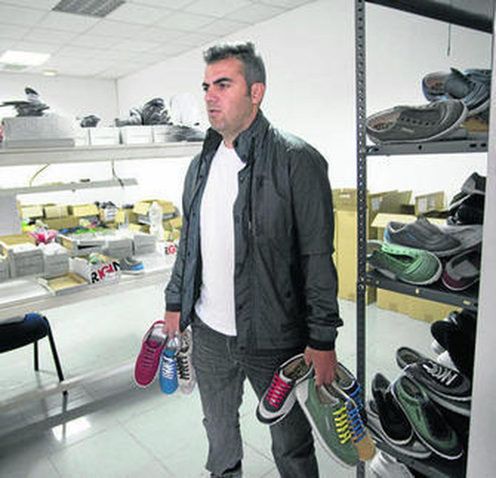 Pedro Franco, con varios modelos de zapatillas D'Original, en el almacén de la empresa.