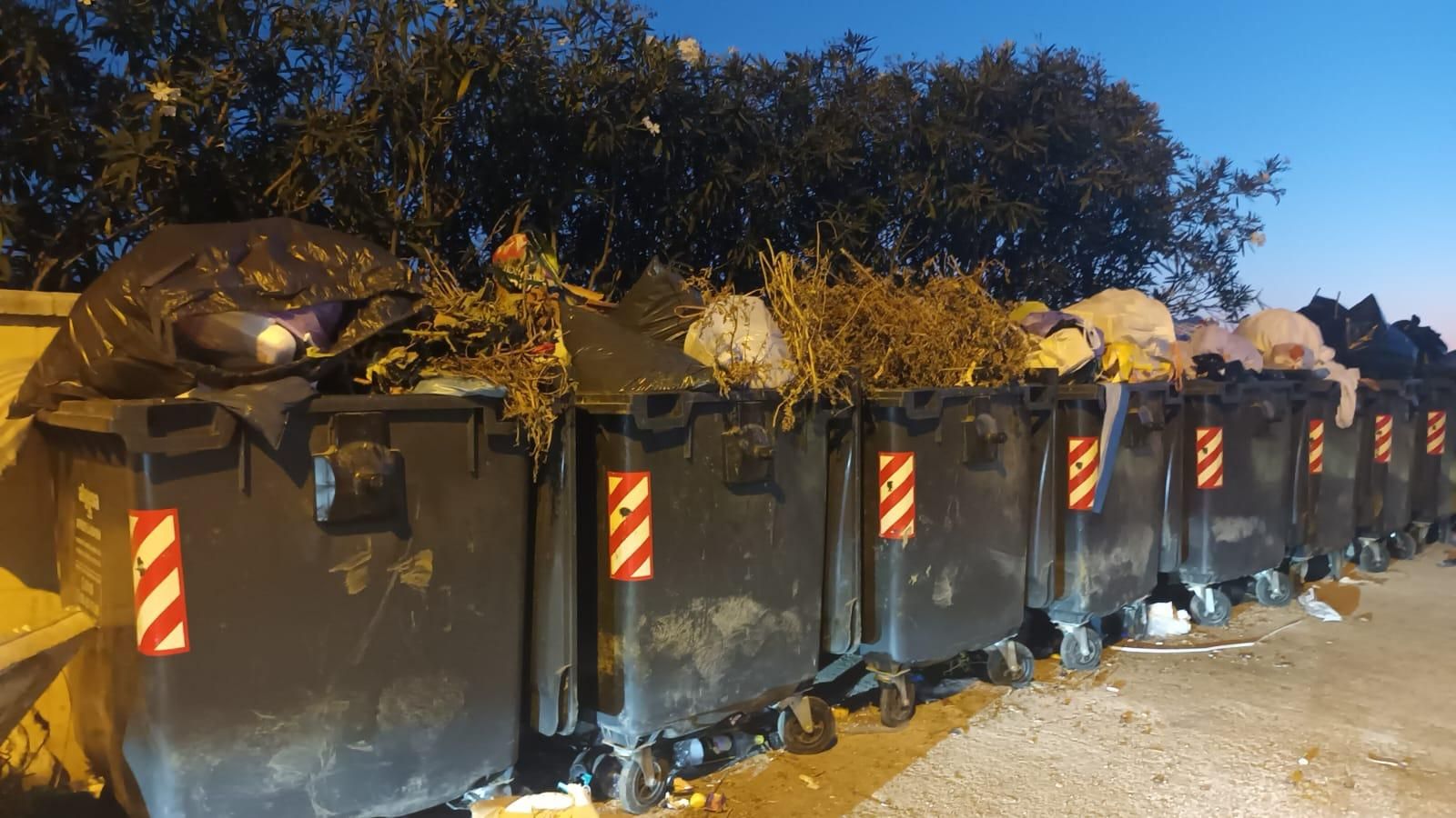 Varios contenedores de basura hasta arriba.