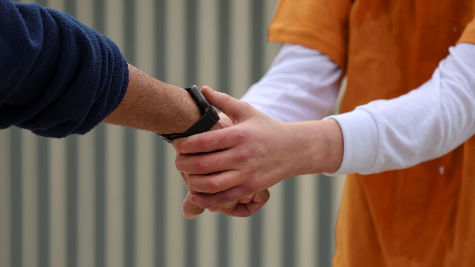 Un trabajador dándole la mano a un usuario del centro. Un trabajador dándole la mano a un usuario del centro.