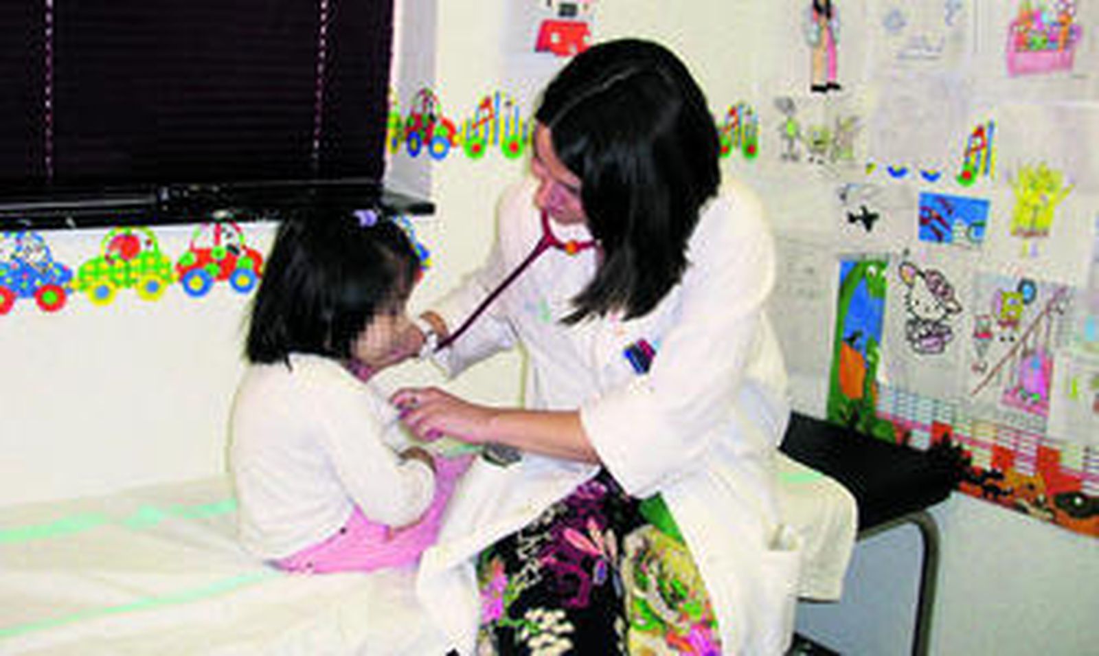 Una pediatra examina a una niña en una consulta médica.