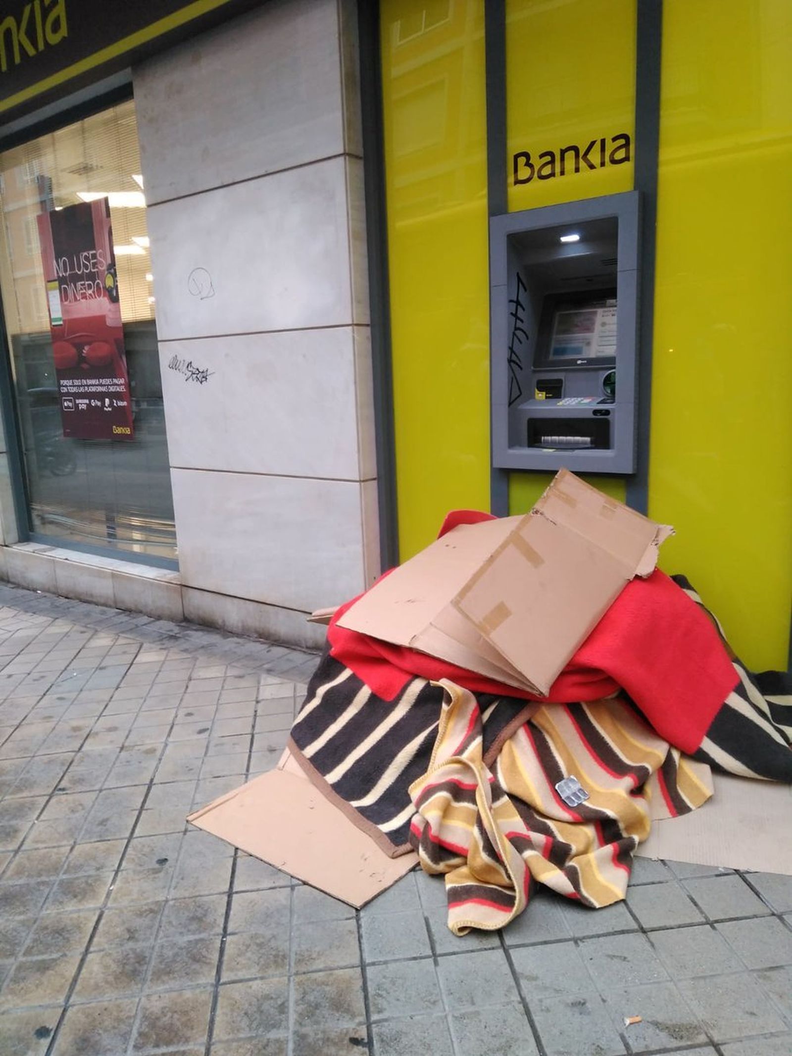 Las mantas y cartones del fallecido.