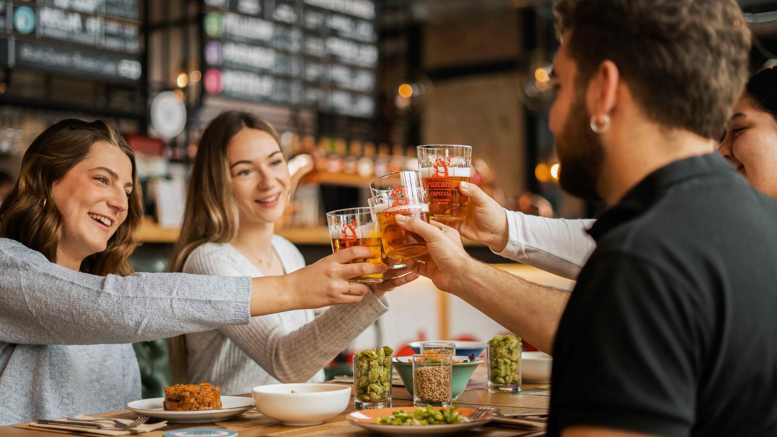 Varias personas disfrutan de una cerveza en Factoría Cruzcampo.