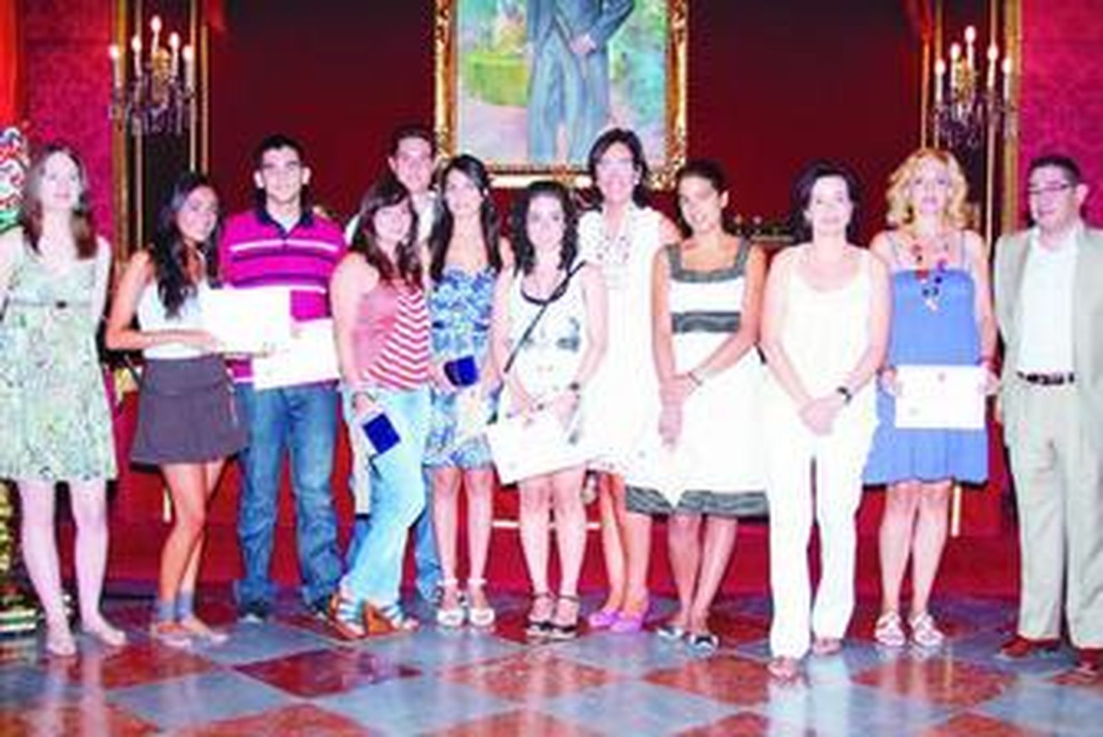María Francés, en el centro, e Inmaculada Marrero, tercera por la derecha, junto a los nueve estudiantes homenajeados en el Ayuntamiento.