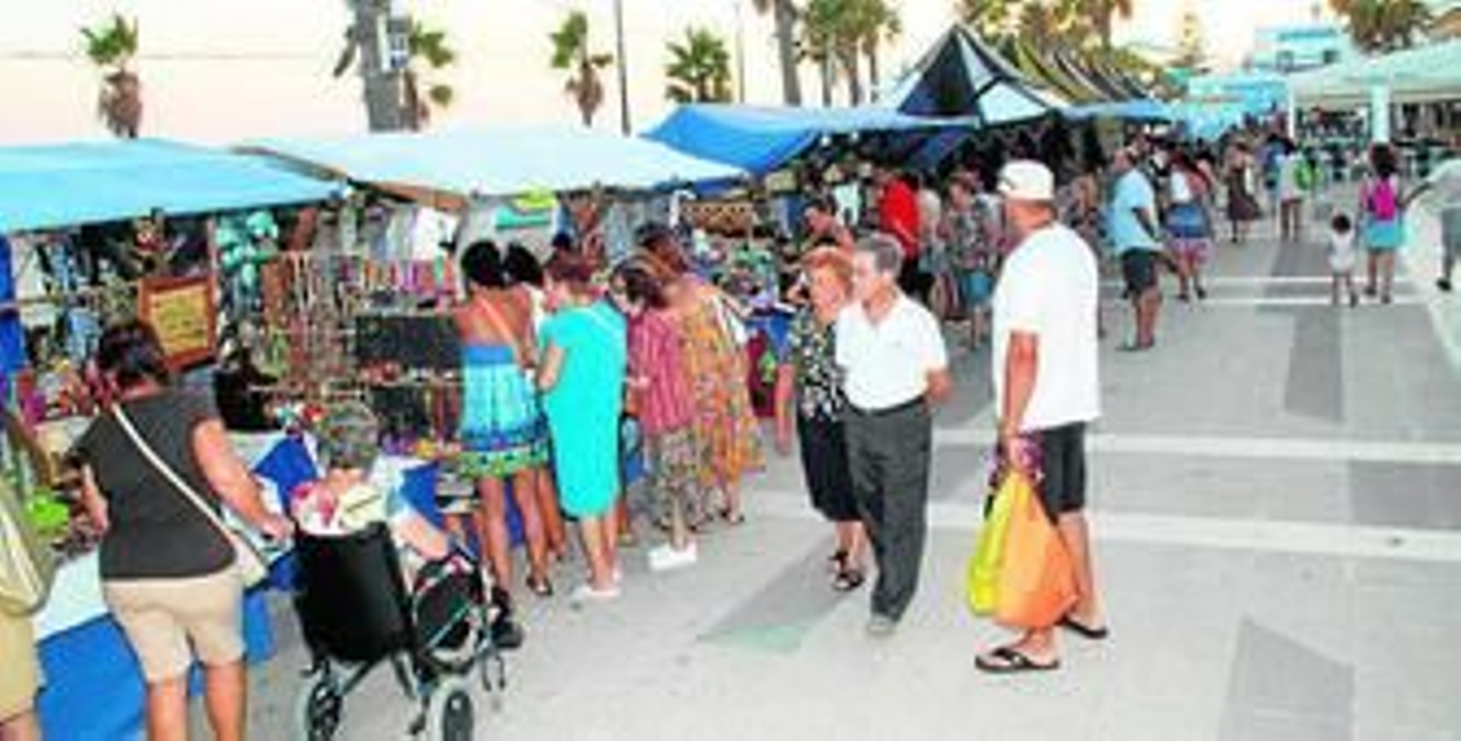Los veraneantes de La Antilla siguen con interés la oferta del Mercado Marinero desde el viernes.