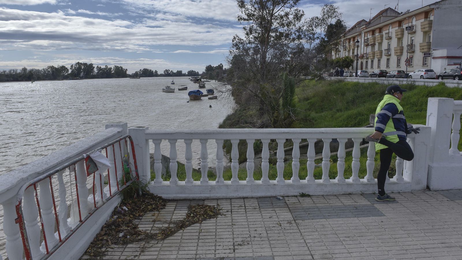 Un hombre realiza ejercicios apoyado en la balaustrada. A la izquierda, vista del tablestacado desde el río.