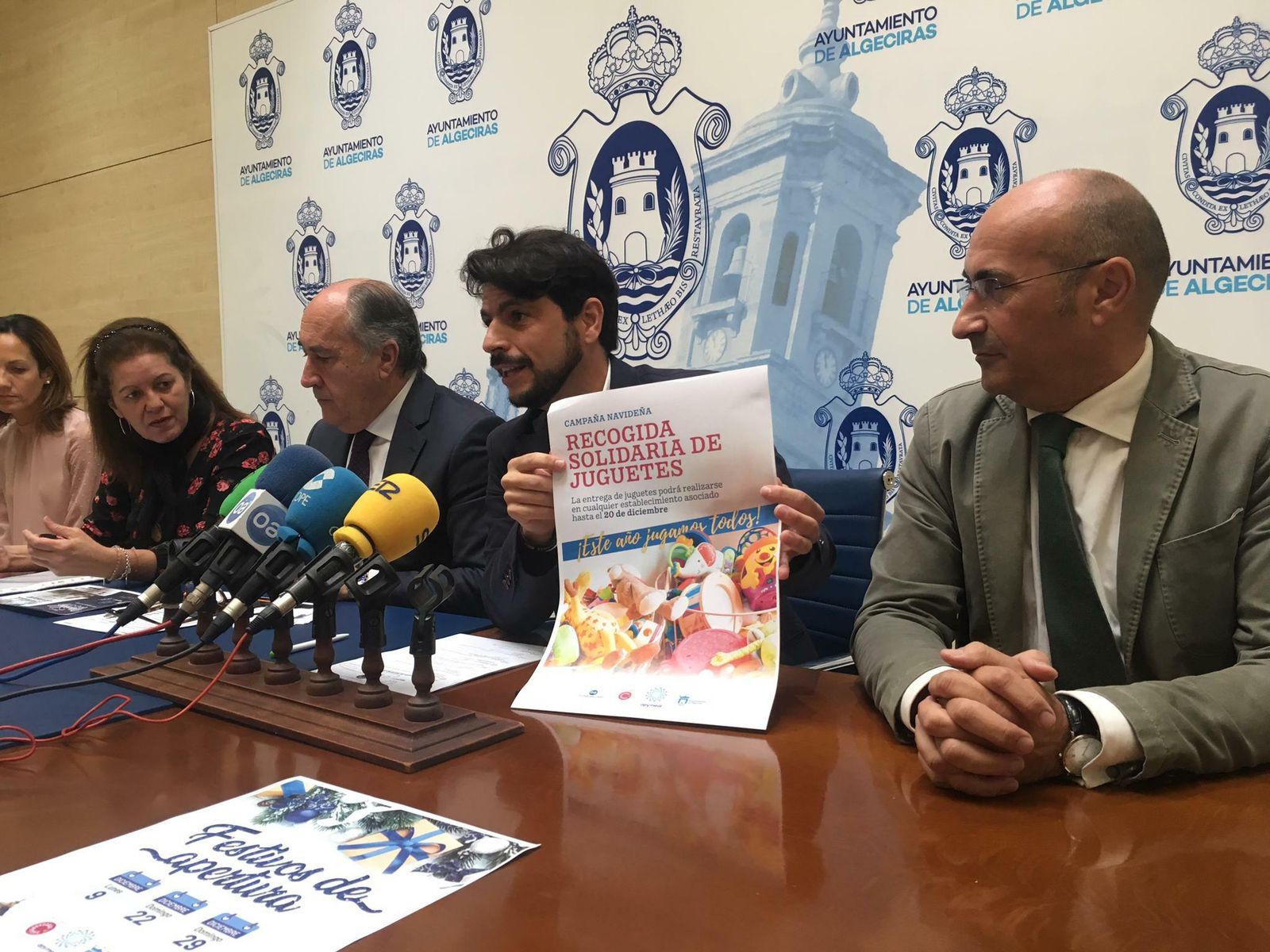 El concejal Sergio Pelayo muestra junto al alcalde de Algeciras y la presidenta de Apymeal uno de los carteles de la campaña